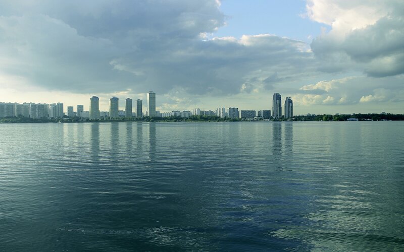 City Skyline Across Water — Blue, Calm, Afternoon, Photograph, Skyscrapers
