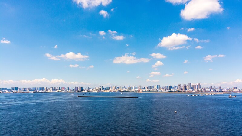 City Skyline Across Water — Blue, Serene, Afternoon, Photograph, Sky