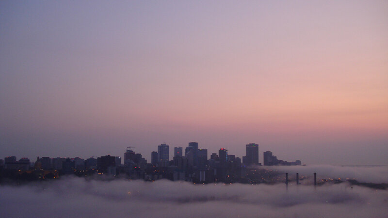 City skyline at dawn with fog