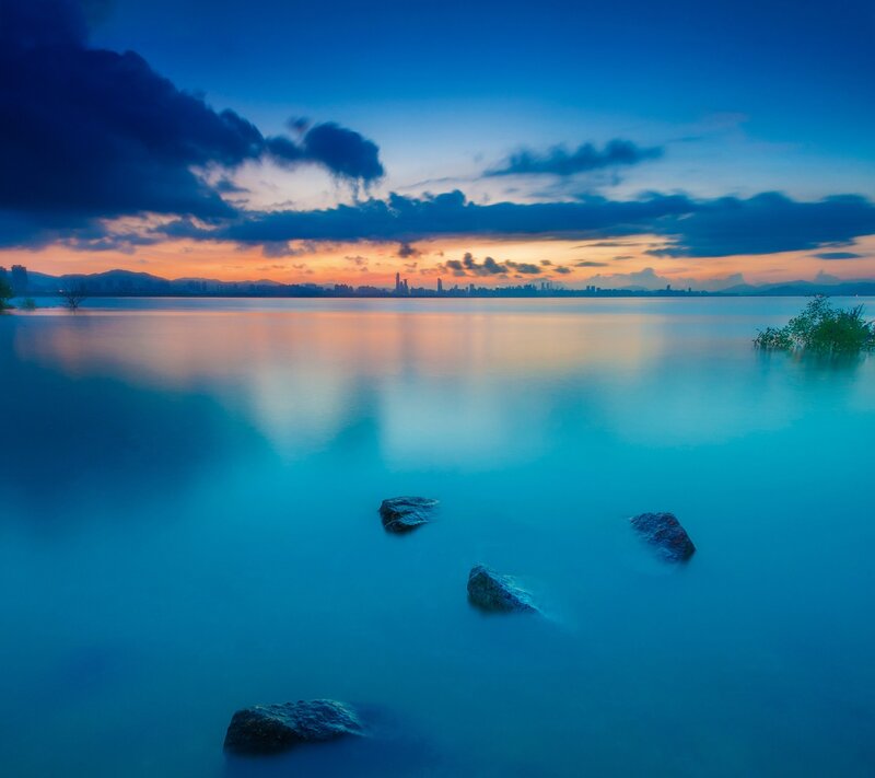 City Skyline at Dusk — Blue, Serene, Sunset, Photograph, Rocks