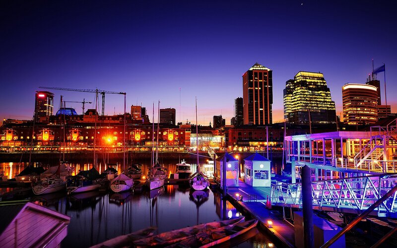 city skyline at dusk with boats