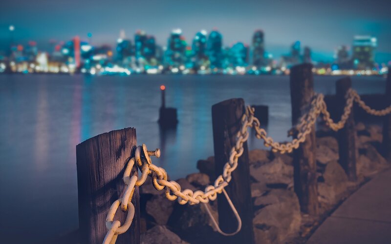 City skyline at dusk with chain barrier