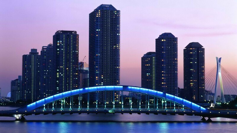 City skyline at dusk with illuminated bridge