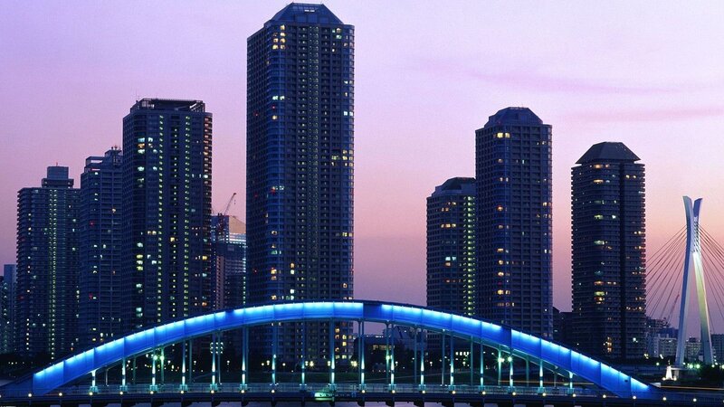 City skyline at dusk with illuminated bridge
