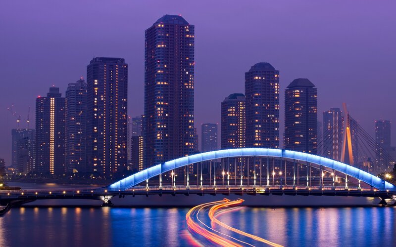 City skyline at dusk with illuminated bridge