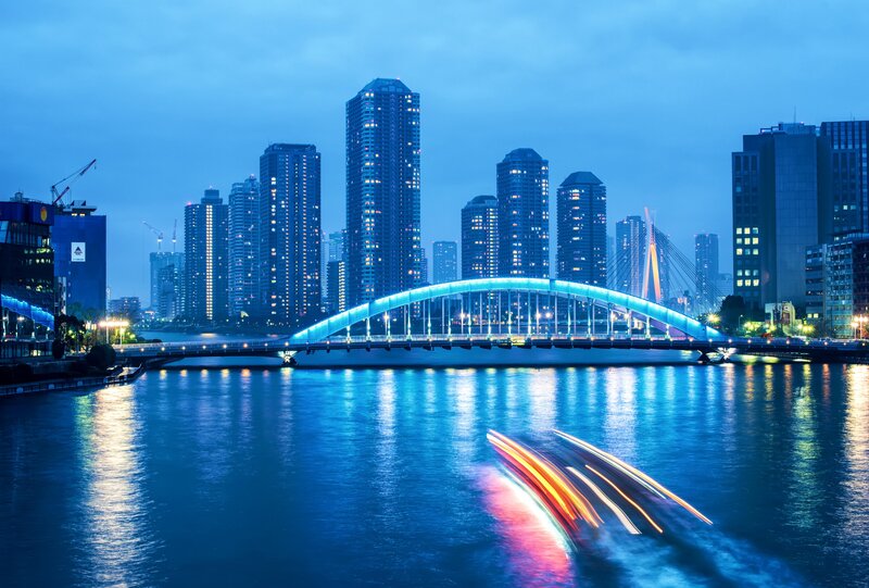 City skyline at dusk with illuminated bridge