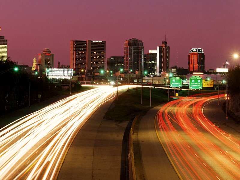 City skyline at dusk with traffic trails