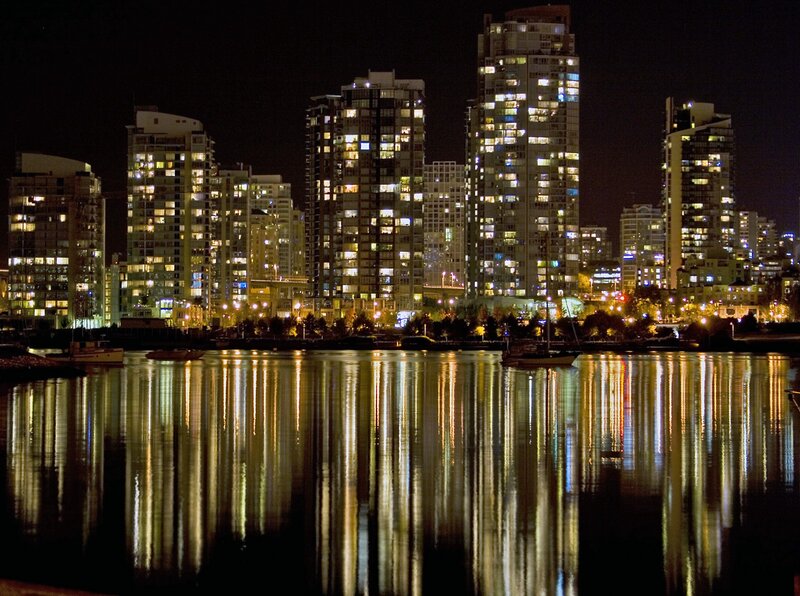 City Skyline at Night — Black, Calm, Photograph, Buildings, Water, Boats, Yellow