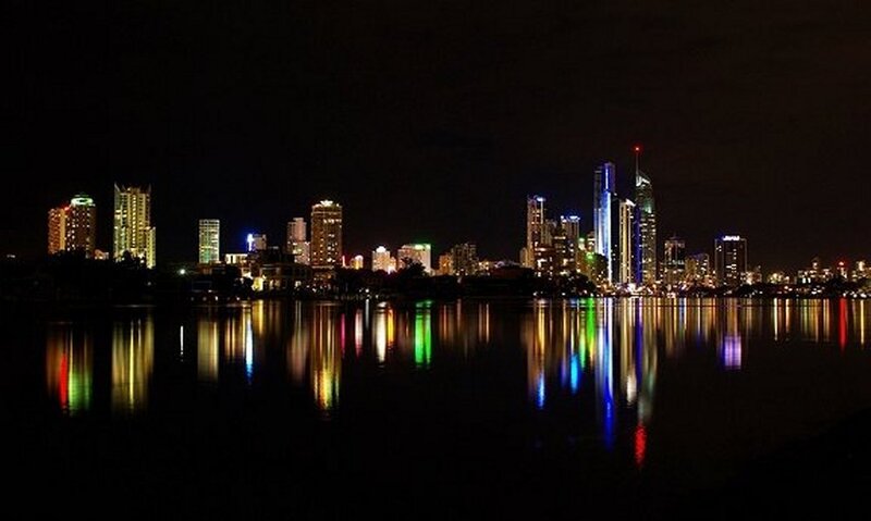 City Skyline at Night — Black, Calm, Photograph, Buildings, Water, Lights, Blue, Yellow