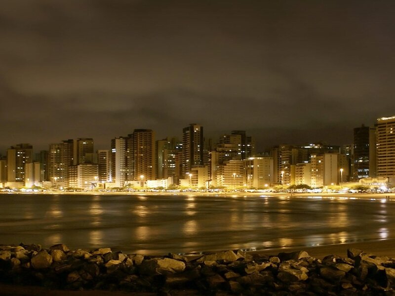 City Skyline at Night — Black, Calm, Photograph, Buildings, Water, Rocks