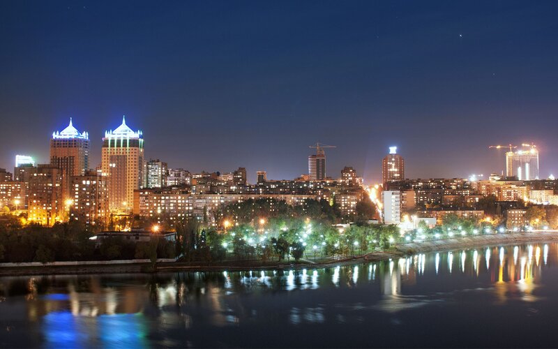 City Skyline at Night — Blue, Calm, Photograph, Buildings, River, Trees