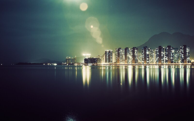 City Skyline at Night — Blue, Serene, Photograph, Buildings, Mountains