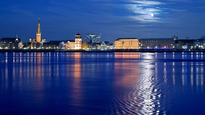 City Skyline at Night — Blue, Serene, Photograph, Moon, River, Buildings