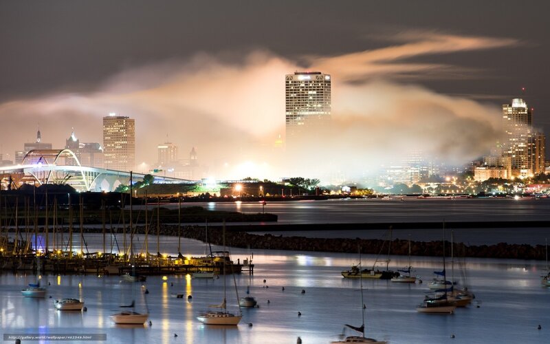 City skyline at night with boats