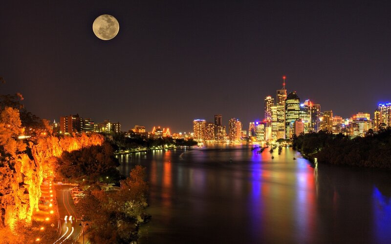 City skyline at night with full moon