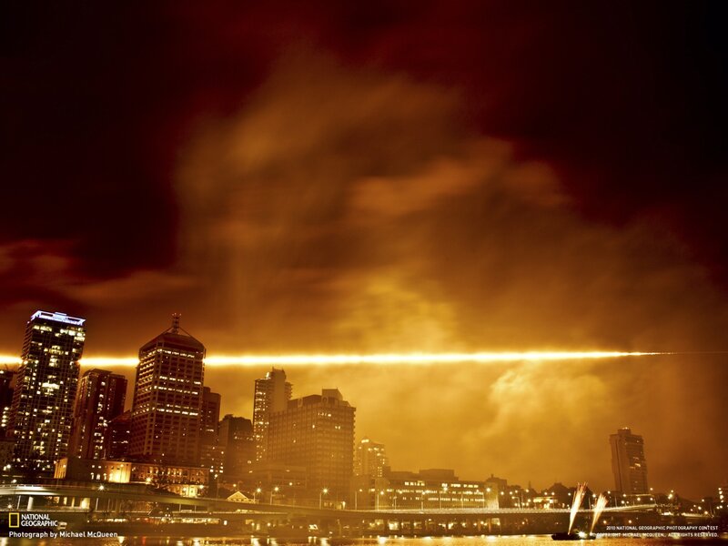 City skyline at night with light beam