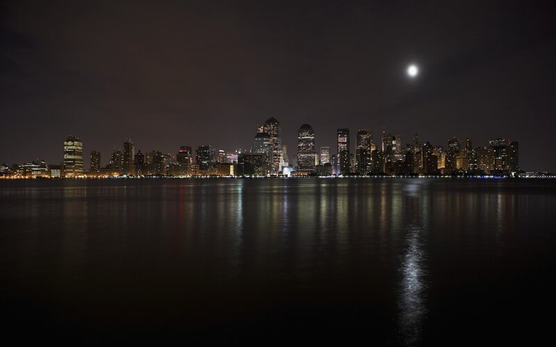 City skyline at night with moon