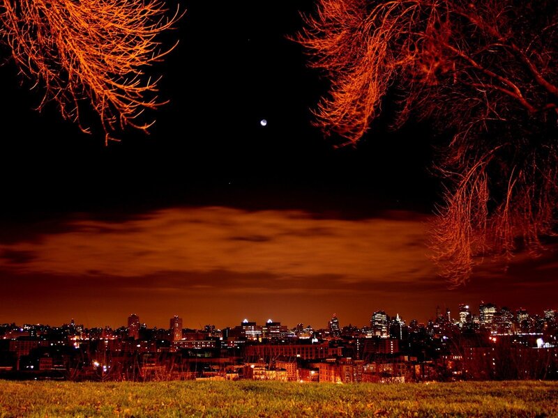 City skyline at night with moon