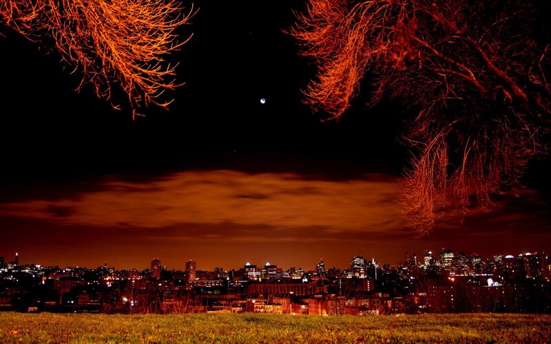 City skyline at night with moon