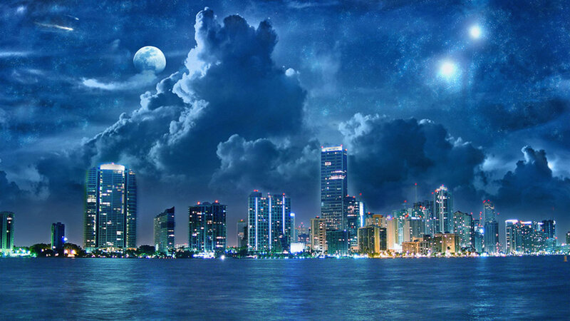 City skyline at night with moon