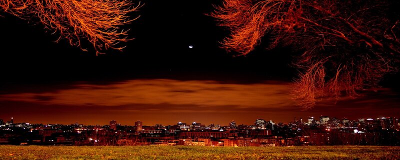 City skyline at night with moon