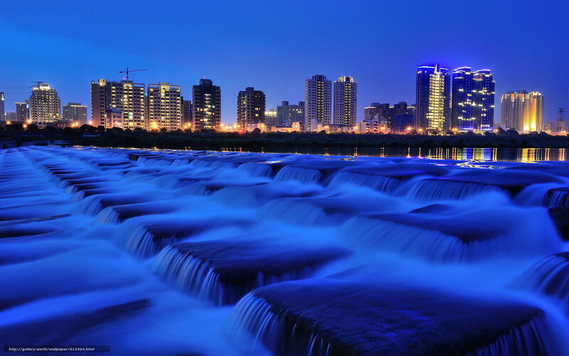 City skyline at night with waterfalls