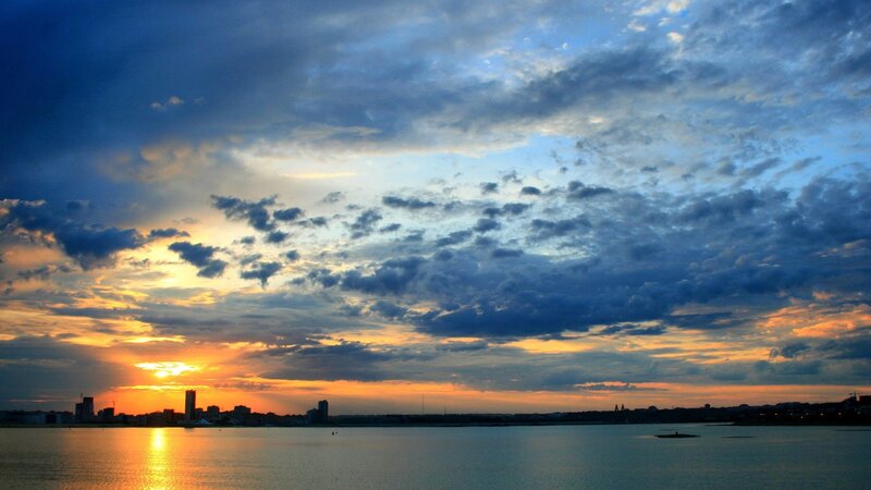 City Skyline at Sunset — Blue, Dramatic, Photograph, Sky, Clouds, Water, Buildings, Orange