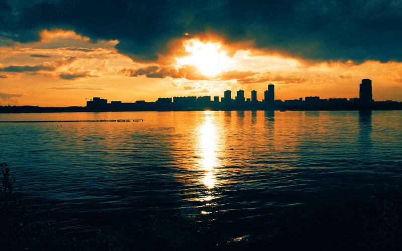 City Skyline at Sunset — Orange, Dramatic, Photograph, Water, Sun