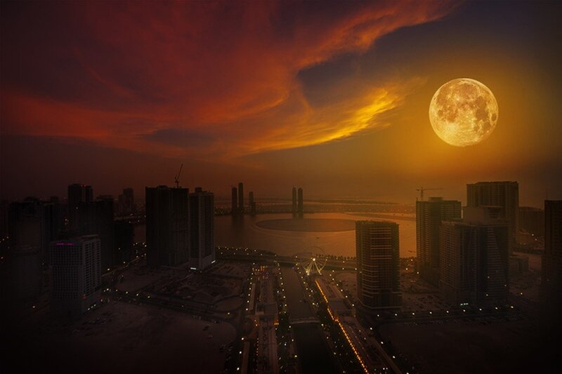 City skyline at sunset with full moon