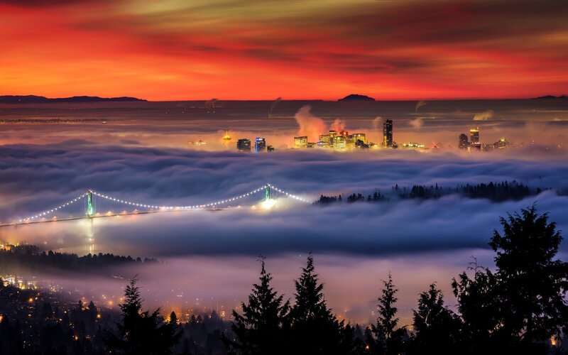 City skyline over fog at sunset