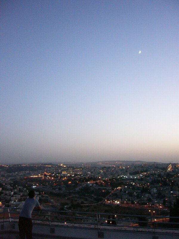 City view at dusk with crescent moon