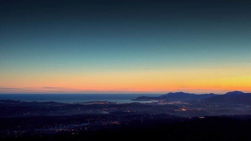 Cityscape at Dusk — Blue, Serene, Sunset, Photograph, Mountains, Sea