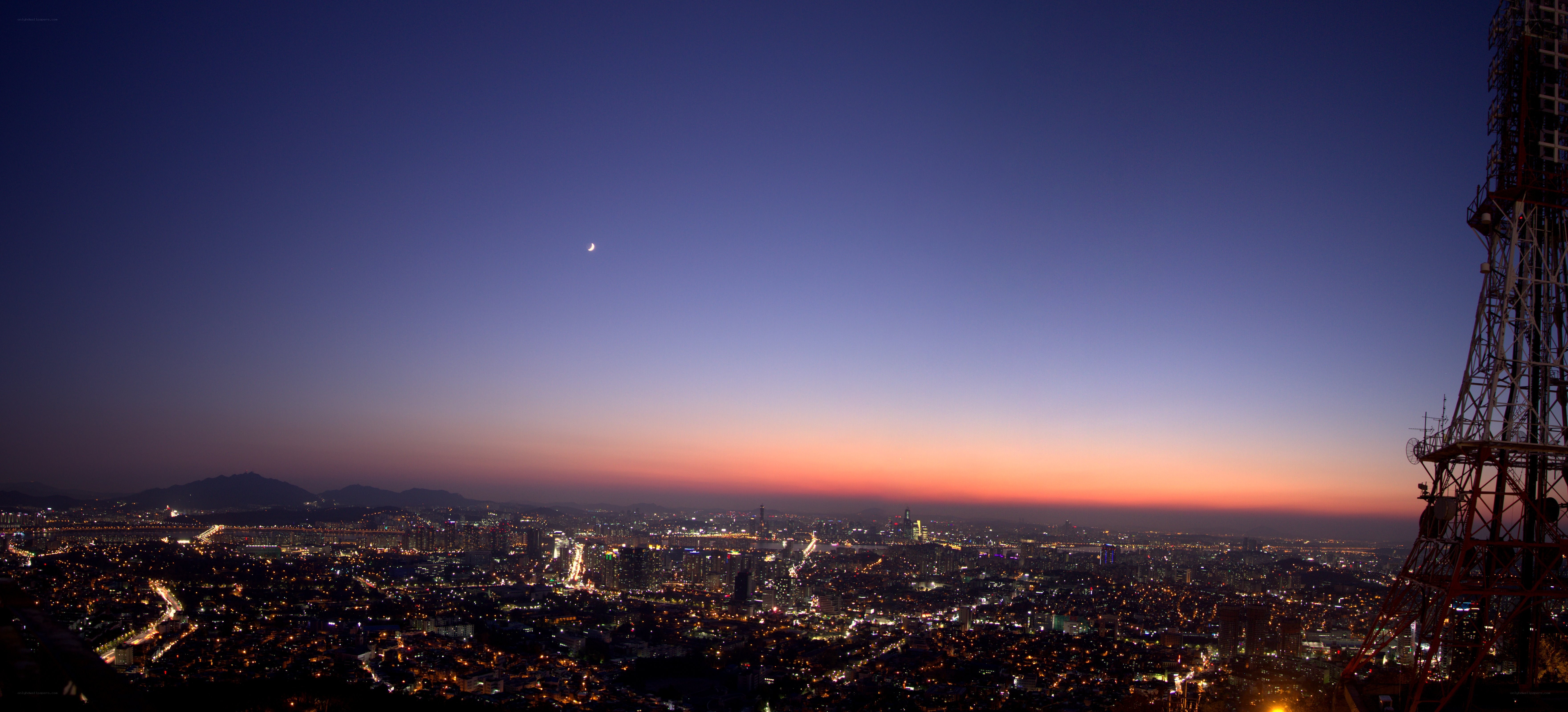 cityscape at dusk with crescent moon