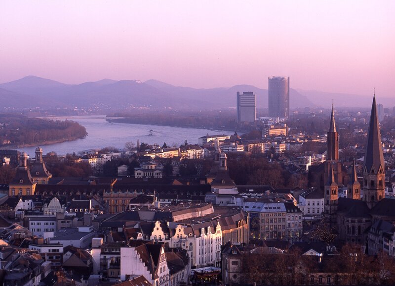 Cityscape at dusk with river and mountains