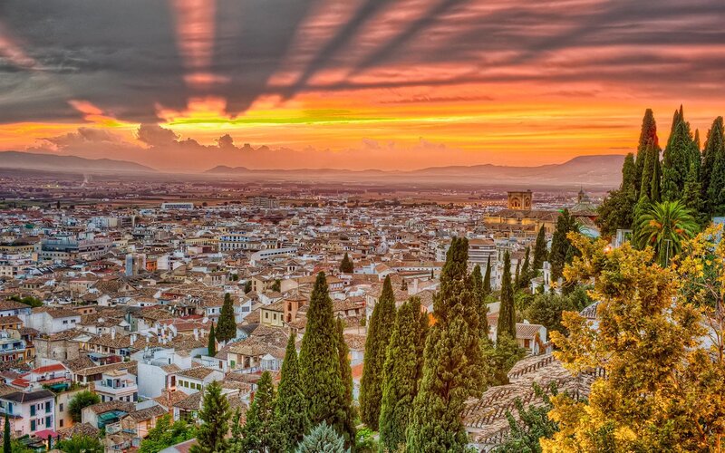 Cityscape at Sunset — Orange, Dramatic, Photograph, Buildings, Trees, Mountains