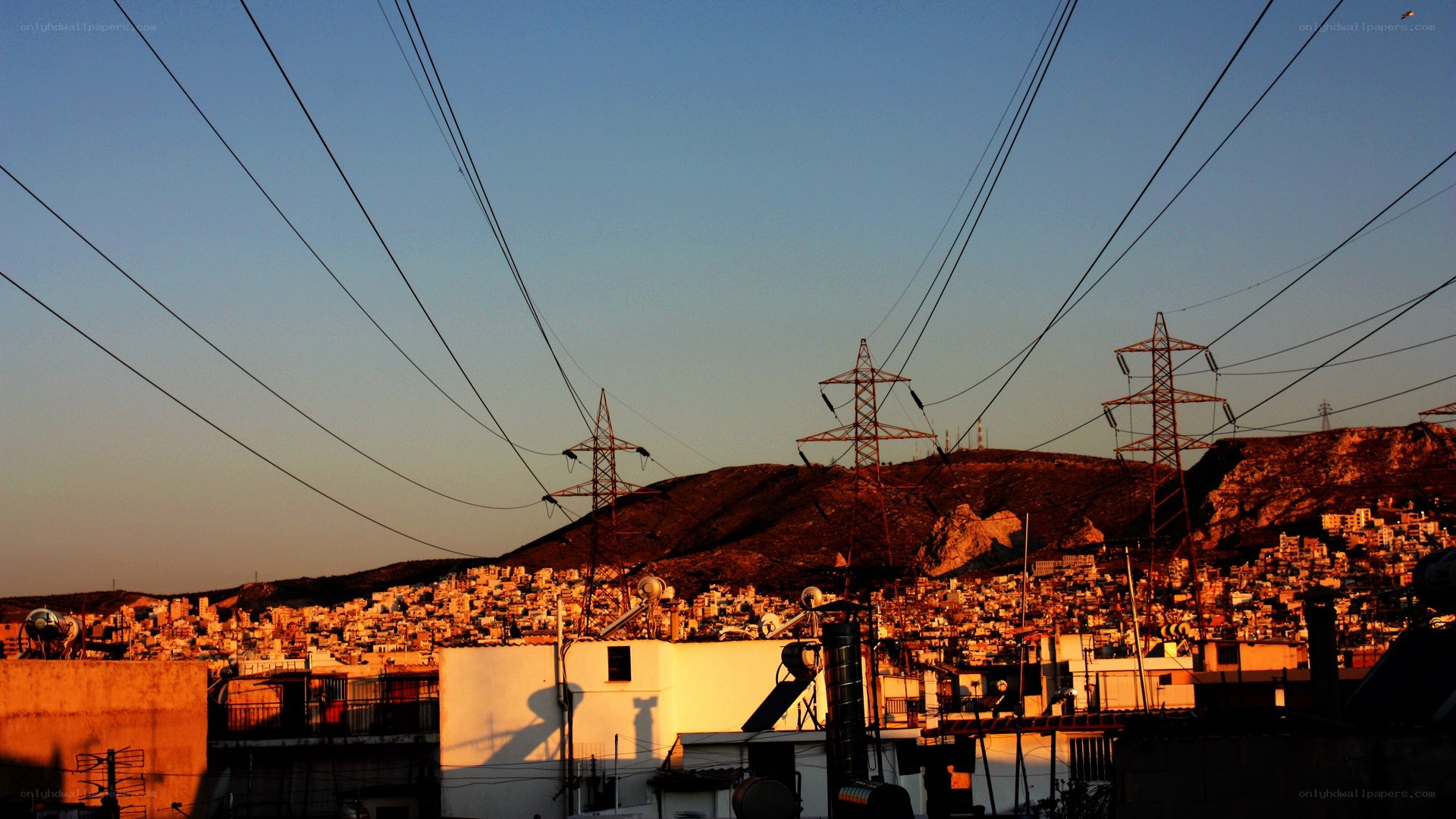 Cityscape at sunset with power lines