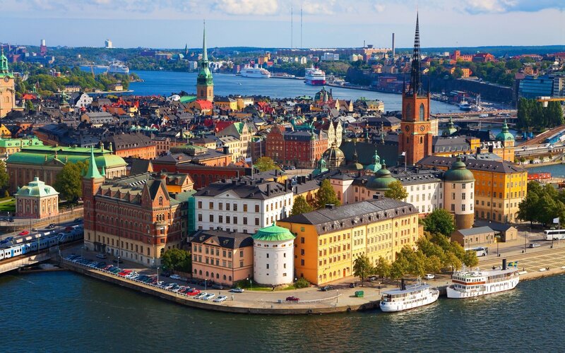 Cityscape of Stockholm — Blue, Serene, Afternoon, Photograph, Buildings, Churches, Boats