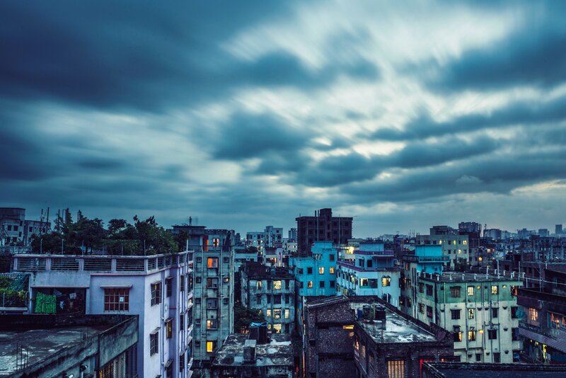 Cityscape under Cloudy Sky — Blue, Dramatic, Night, Photograph
