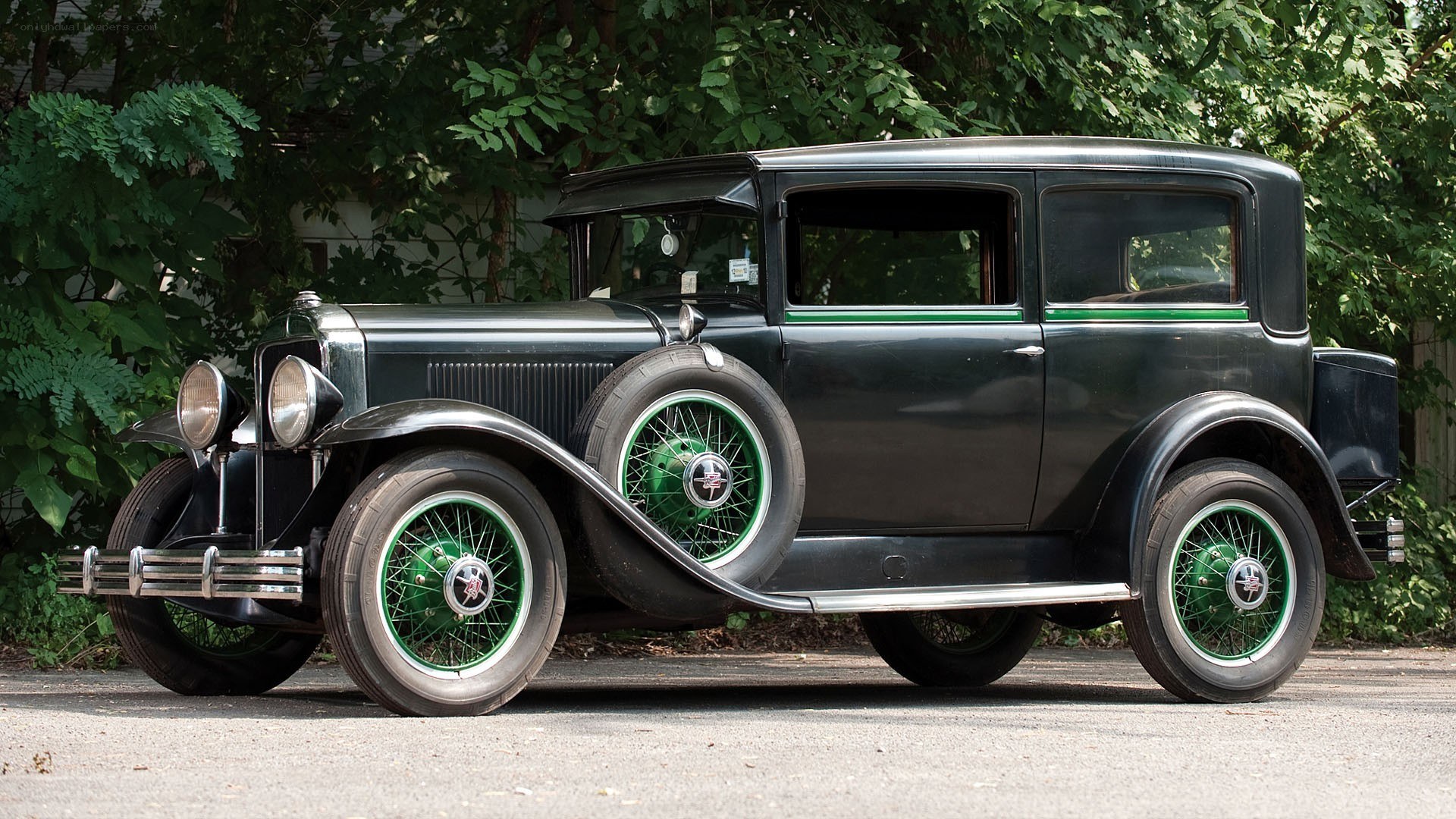 Classic black car with green wheels