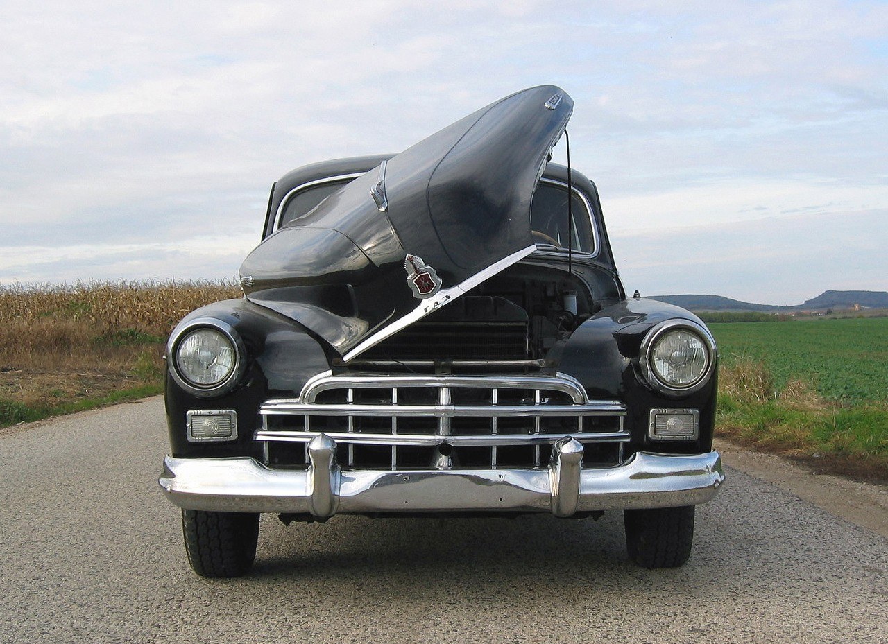 Classic black car with open hood