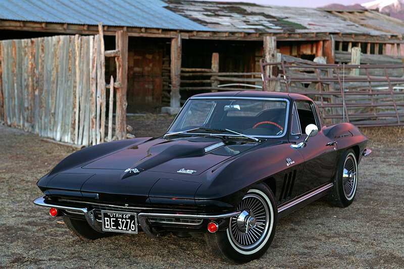 Classic black Corvette in front of barn