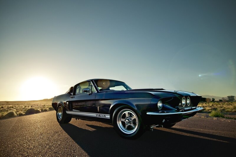 Classic black muscle car at sunset