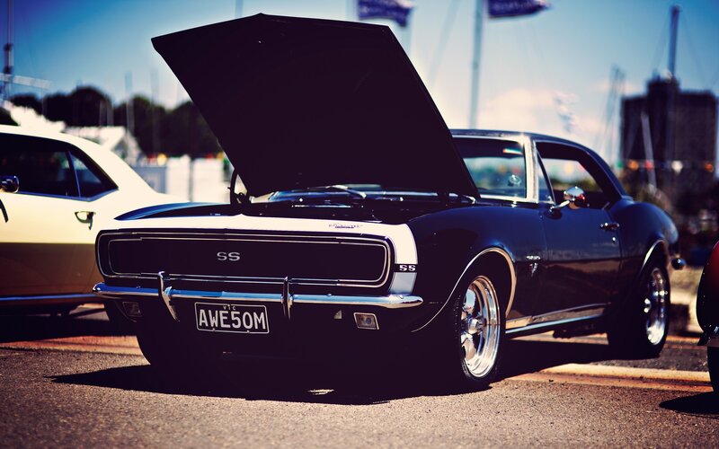 Classic black muscle car with open hood