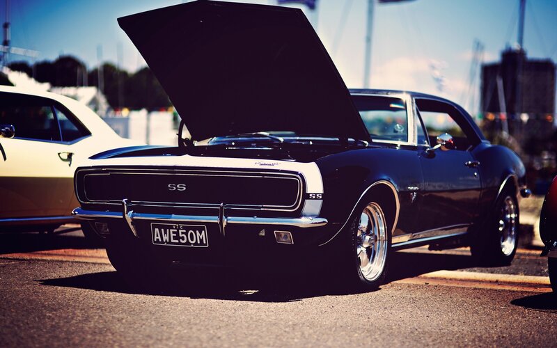 Classic black muscle car with open hood