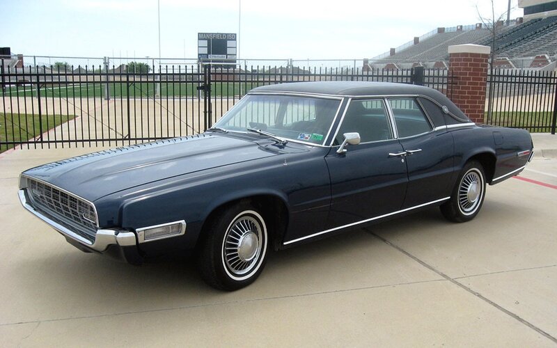 Classic blue sedan at stadium