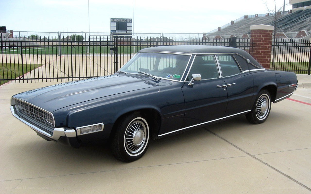 Classic blue sedan at stadium