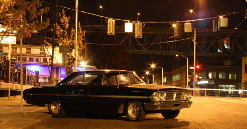 Classic car at night on city street