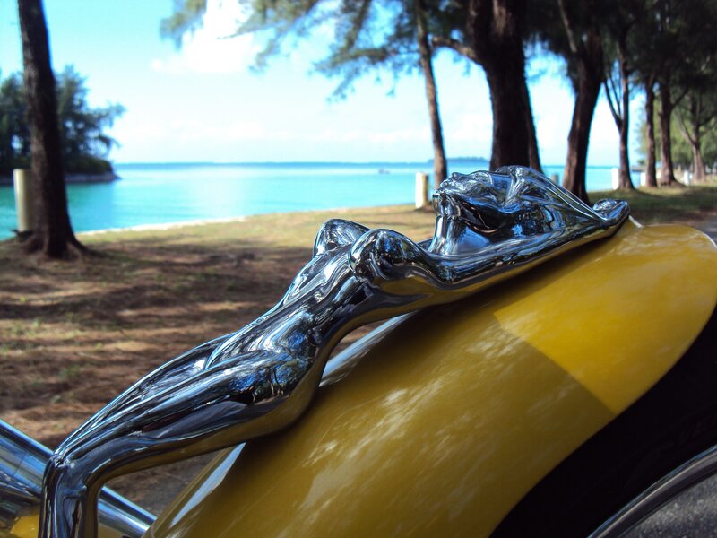 Classic car hood ornament by the sea