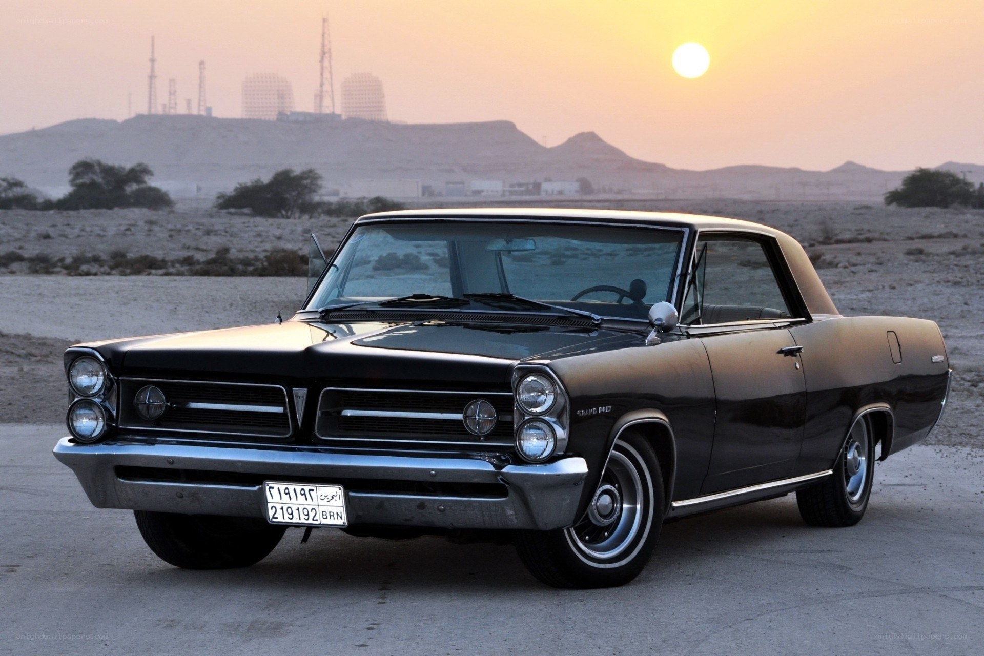 Classic car in desert at sunset