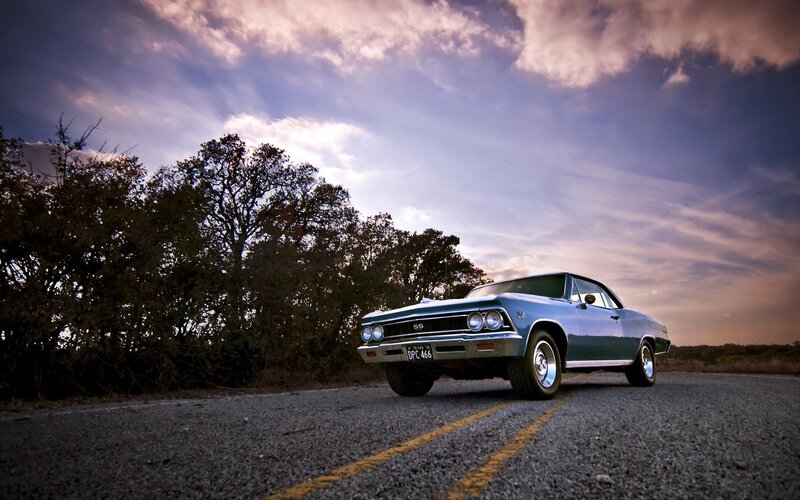 Classic car on a road at sunset